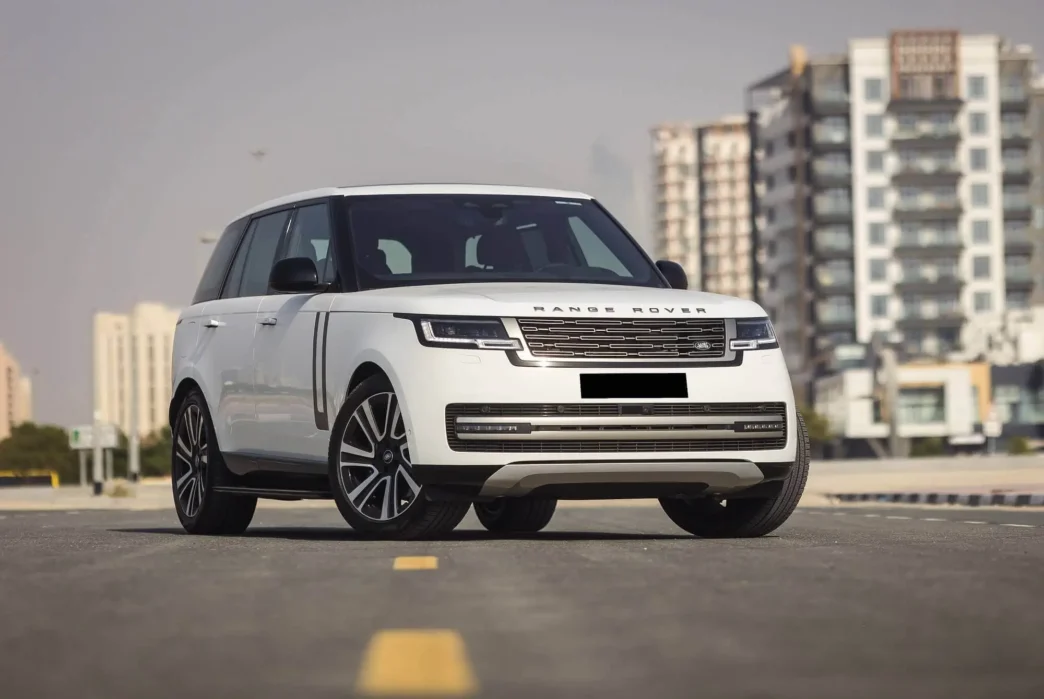 White Range Rover driving through Colombo city streets with modern skyline in the background.