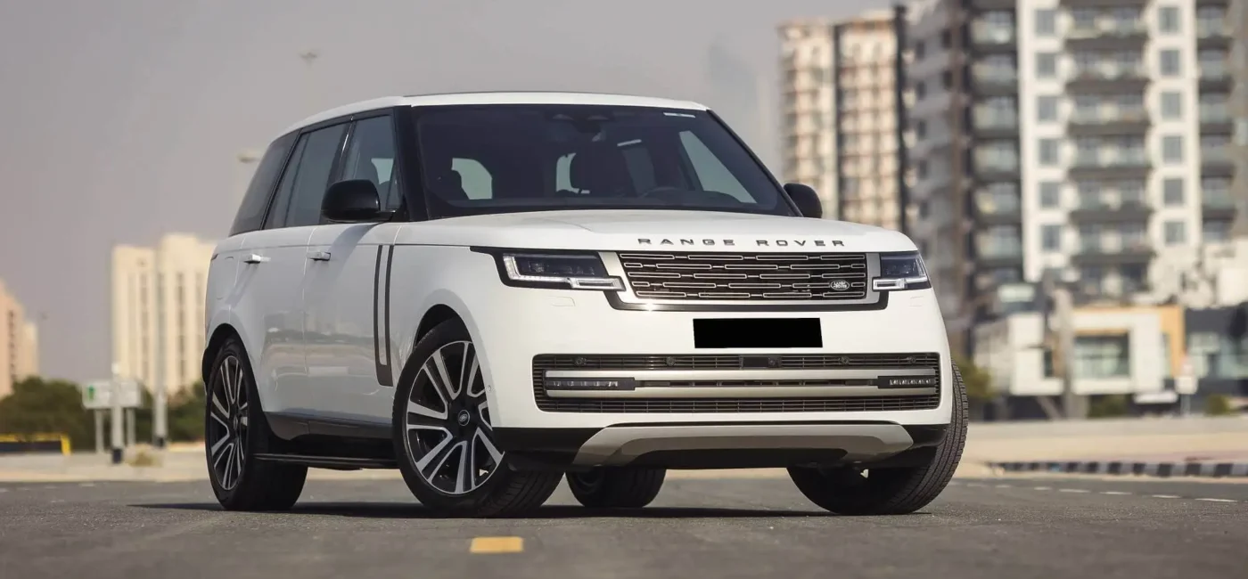 White Range Rover driving through Colombo city streets with modern skyline in the background.
