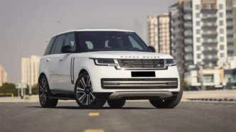 White Range Rover driving through Colombo city streets with modern skyline in the background.