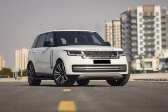 White Range Rover driving through Colombo city streets with modern skyline in the background.