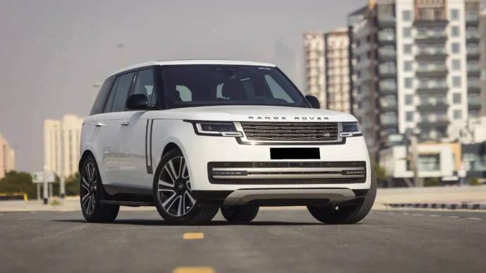 White Range Rover driving through Colombo city streets with modern skyline in the background.